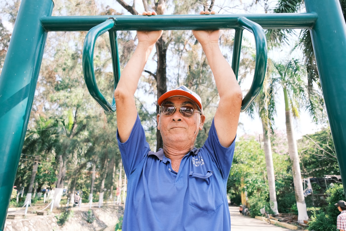 Trainer assisting a mature man with proper lifting technique